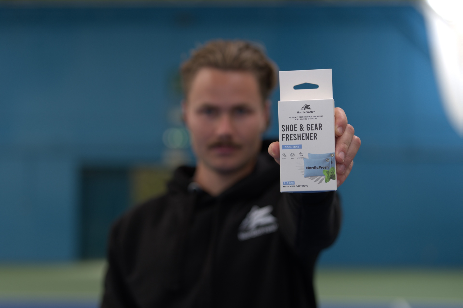 Two athletes at the gym holding NordicFresh Cool Mint bamboo charcoal shoe & gear fresheners