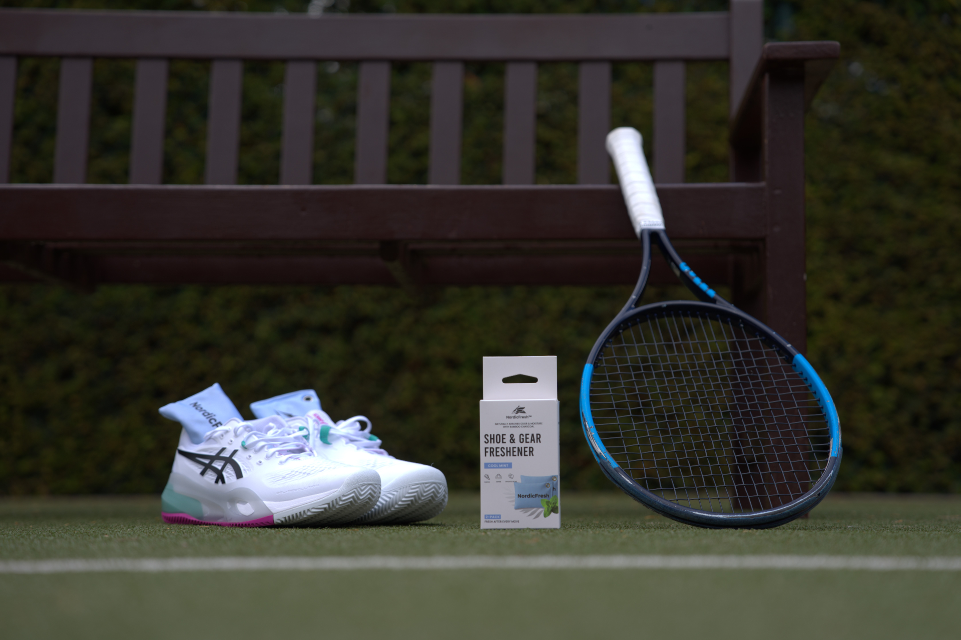 NordicFresh Cool Mint shoe & gear freshener with tennis shoes and racket beside a courtside gym bag